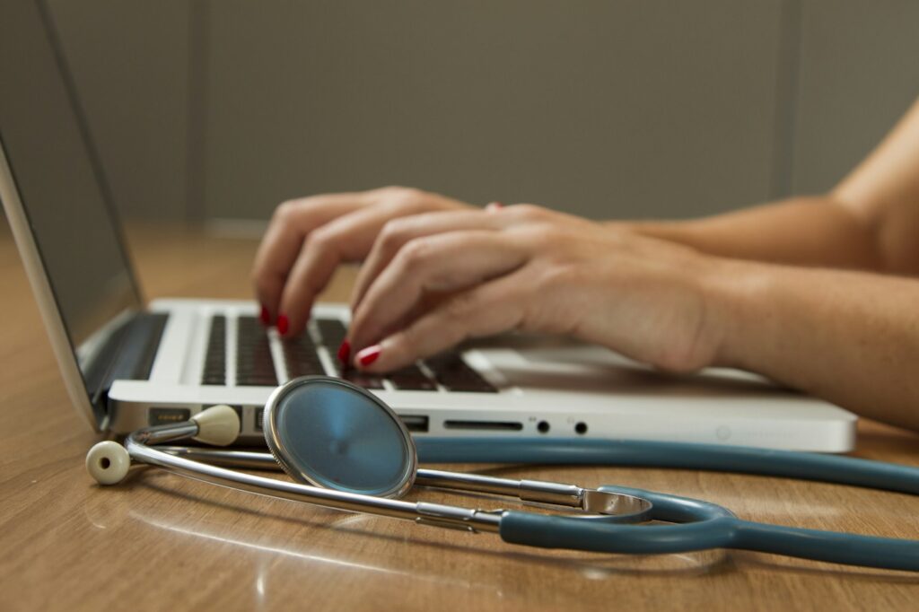 Stethoscope beside a laptop used for healthcare work